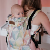 Mother carrying a baby in the Didymos didyfix soft structured cotton baby carrier in zephyr in the back position 