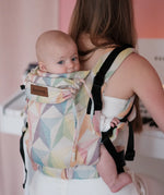 Mother carrying a baby in the Didymos didyfix soft structured cotton baby carrier in zephyr in the back position 