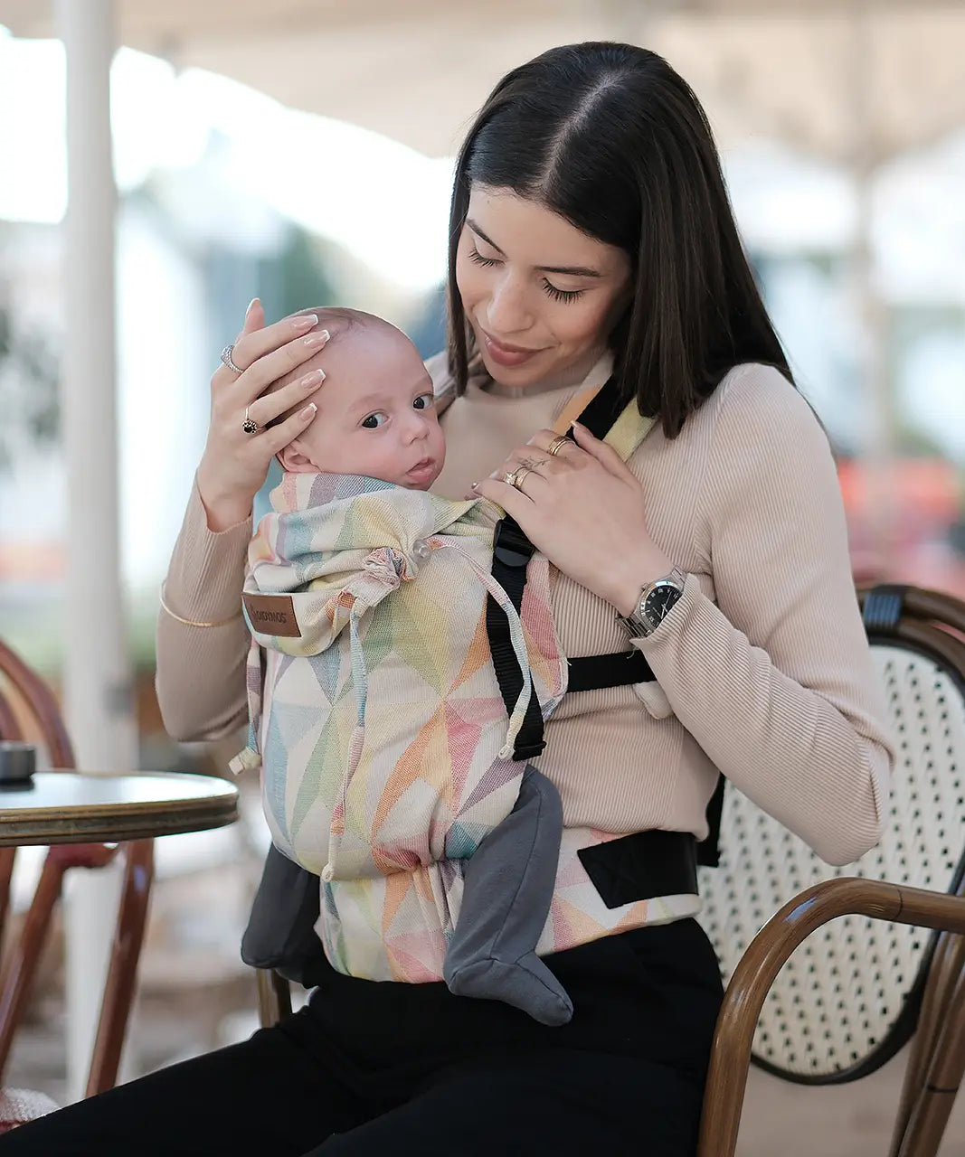 Mother carrying a baby in the Zephyr Didymos didyfix full buckle cotton carrier in the frontal position 