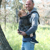 Father carrying a toddler in the blue blossom Didymos didyfix full buckle toddler carrier in the frontal position.  