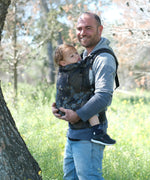 Father carrying a toddler in the blue blossom Didymos didyfix full buckle toddler carrier in the frontal position.  
