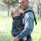 Side of father carrying a toddler in the blue blossom Didymos didyfix toddler carrier in the frontal position with the neck rest adjusted to the head