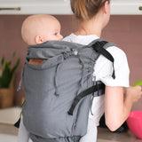 Woman carrying a small child on the back with a Didymos didyfix double anthracite toddler carrier showing neck rest adjusted to baby's head position