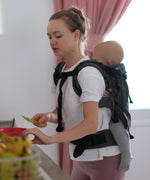 Side of woman carring a small child on the back with a Didymos didyfix double anthracite toddler carrier showing shoulder and waist buckles fastened
