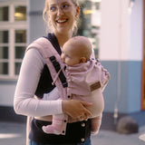Mother carrying a baby in the cinammon Didymos didyflow half buckle carrier in the frontal postion 