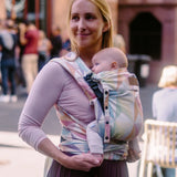 Mother carrying a baby in the zephyr  Didymos didyflow half buckle half tie cotton carrier in the frontal position
