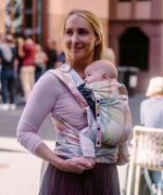 Mother carrying a baby in the zephyr  Didymos didyflow half buckle half tie cotton carrier in the frontal position