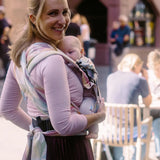 Back of mother wearing a Didymos didyflow zephyr baby carrier showing half buckle half tie waist belt and double layered tie on shoulder straps