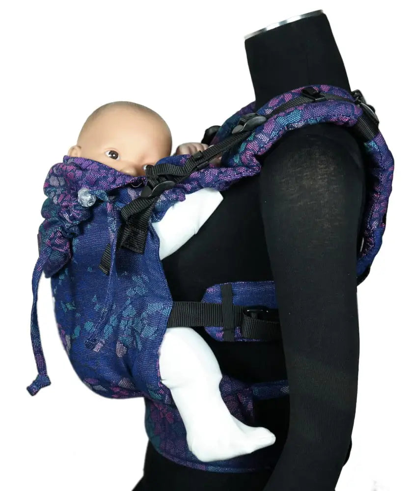 Side of Didymos didyfix carrier in mosaic in the dark design shown on mannequin. A soft structured full buckle carrier made from cotton