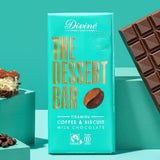 The Divine Tiramisu Dessert Bar shown in it's wrapping. An unwrapped bar can be seen on one side with a piece of tiramisu and coffee beans on the other side. 