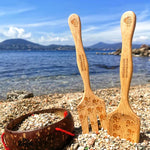 Dr Zigs Beach Creativity Kit shown on pebbles. The kit includes two bamboo tools and a coconut bowl. A mountain can be seen in the background