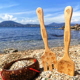 Dr Zigs Beach Creativity Kit shown on pebbles. The kit includes two bamboo tools and a coconut bowl. A mountain can be seen in the background