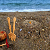 A mandala shape in the sand created using the bamboo tools for the Dr Zigs beach creativity set. The Kit is placed beside the mandala on the sand