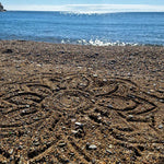 A mandala shape in the sand created using the bamboo tools for the Dr Zigs beach creativity set