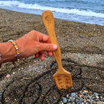 The bamboo spade from the Dr Zigs Beach Creativity Kit being used on a beach to create a mandala shape in the sand