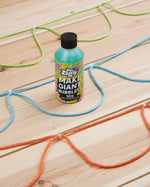 Close up of the Dr Zigs 10x concentrated bubble mixture on a wooden floor next to some coloured rope bubble blowers