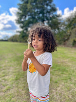 Child blowing bubbles with the small hand wand from the mini bubble kit