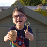 Child holding the small wand shaped like a heart from the mini kit