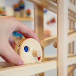 Close up of a hand placing the Fagus wooden bell disc toy on a Fagus marble run set