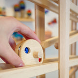 Close up of a hand placing the Fagus wooden bell disc toy on a Fagus marble run set