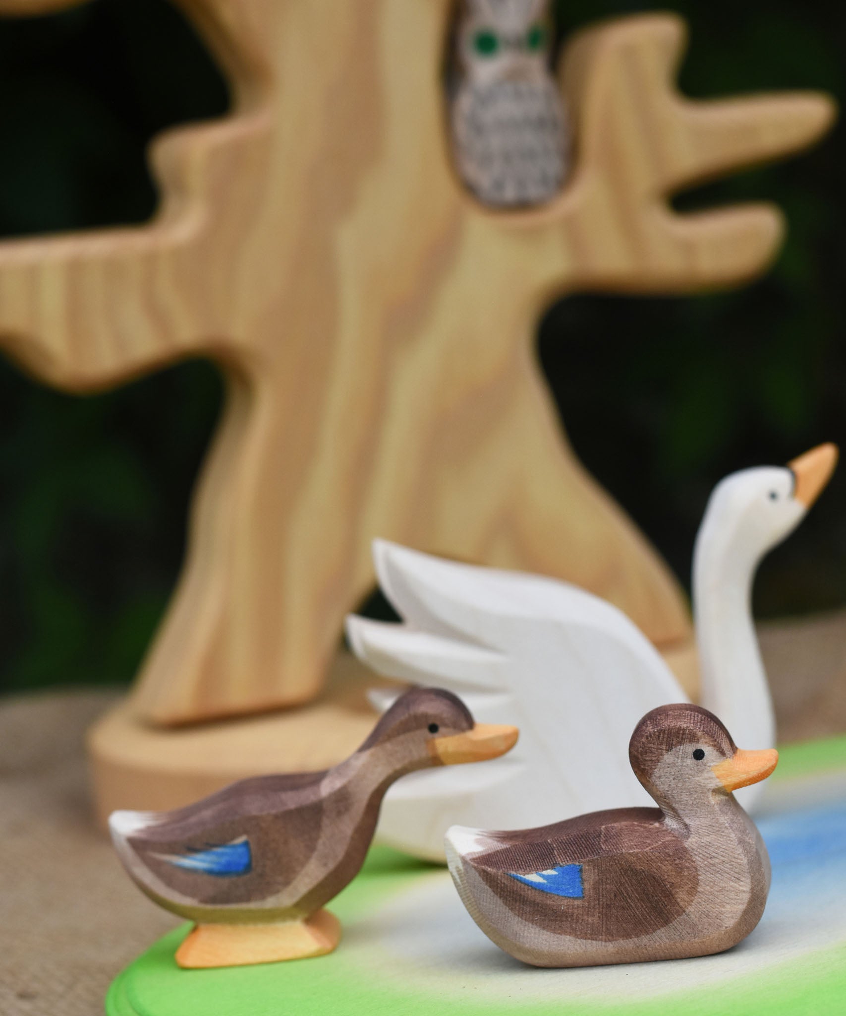 Two Ostheimer wooden ducks placed on a wooden pond scene piece.