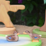 Two Ostheimer wooden ducks placed on a wooden pond scene piece.