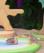 Two Ostheimer wooden ducks placed on a wooden pond scene piece.