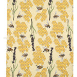 Close up of the DUNS Sweden eco-friendly bee yellow tea towel next to a bar of lemon meringue tony's and a mug of coffee