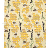 Close up of the DUNS Sweden eco-friendly bee yellow tea towel next to a bar of lemon meringue tony's and a mug of coffee