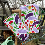 DUNS Sweden organic cotton linen oven glove and tea towel in the cultivate print hanging over the end of a metal chair