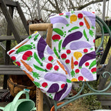DUNS Sweden organic cotton linen oven glove and tea towel in the cultivate print hanging over the end of a metal chair