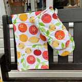 DUNS eco-friendly organic cotton oven glove and tea towel in the citrus print hanging over the end of a black bench