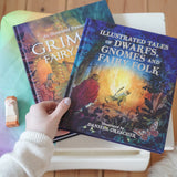 Dwarfs, gnomes and fairy folk children's hardback book by Daniela Drescher stacked on top of Grimm's Fairytales book by same author.