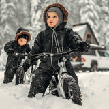 2 kids sat on some Early Rider 12 inch balance bikes in some deep snow