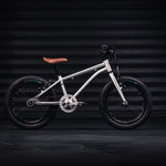 Early Rider silver belter kids bike in a dark workshop