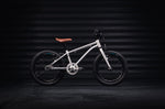 Early Rider silver belter kids bike in a dark workshop
