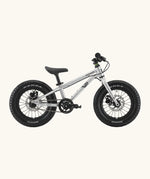 Side of Early Rider kids Seeker 14 inch mountain bike in brushed alloy. Features disk brakes and chunky wheels