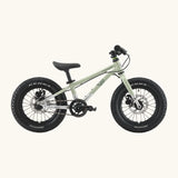 Side of Early Rider kids Seeker 14 inch mountain bike in sage green with a brushed aluminium bottom half frame. Features disk brakes and chunky wheels