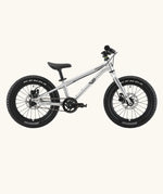 Side of Early Rider kids Seeker 14 inch mountain bike in brushed alloy. Features disk brakes and chunky wheels