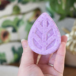 person holding a ecoliving solid shampoo bar in hand