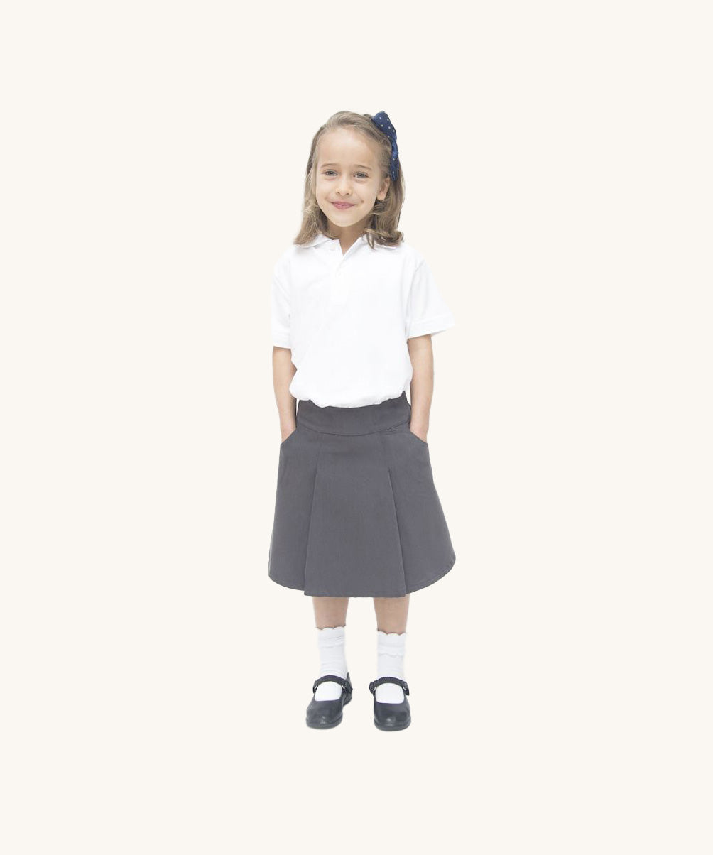 A little girl wearing the Eco Outfitters organic cotton school pleated skirt in grey