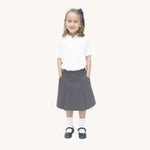 A little girl wearing the Eco Outfitters organic cotton school pleated skirt in grey