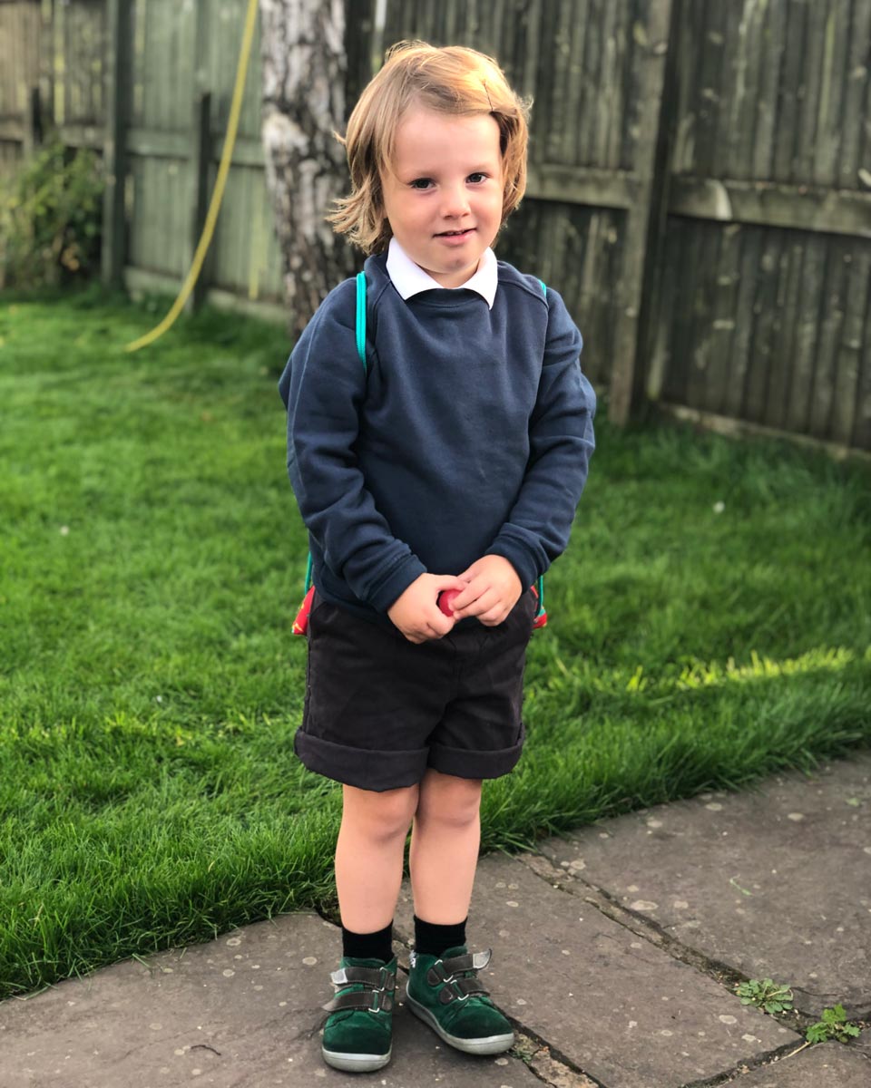 A child wearing an Eco Outfitters organic school jumper in navy.