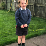 A child wearing an Eco Outfitters organic school jumper in navy.