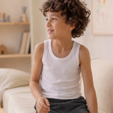 Boy wearing an Eco Outfitters organic cotton vest top for layering under school uniforms. 