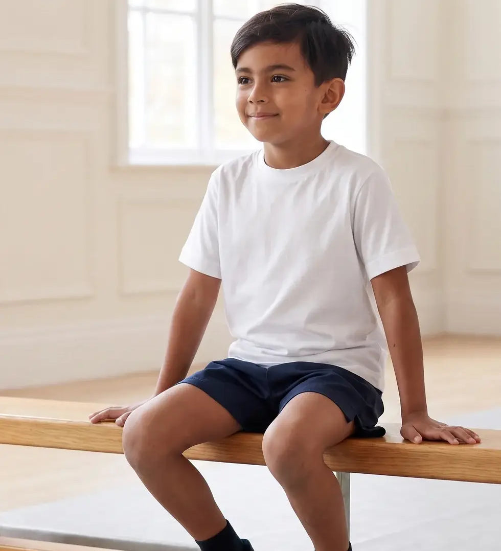 Boy in school PE lesson wearing Eco Outfitters organic cotton white t-shirt and PE shorts. 
