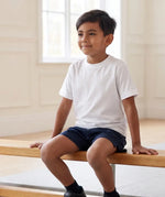 Boy in school PE lesson wearing Eco Outfitters organic cotton white t-shirt and PE shorts. 