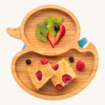 Bamboo duck-shaped weaning plate with fruit and cake.