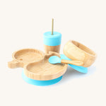 A bamboo baby weaning set by Eco Rascals including a duck-shaped bamboo weaning suction plate, a sippy cup, and a suction bamboo bowl with blue silicone details.