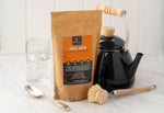 Ecoliving Citric Acid pictured next to wooden dish brush and a kettle